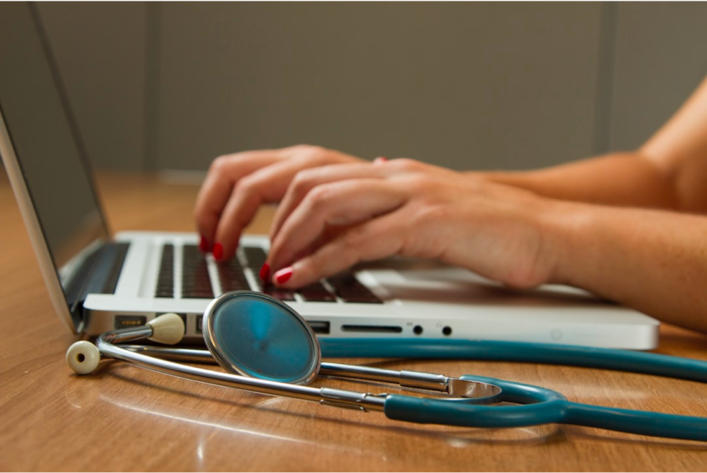 hands at laptop with stethoscope